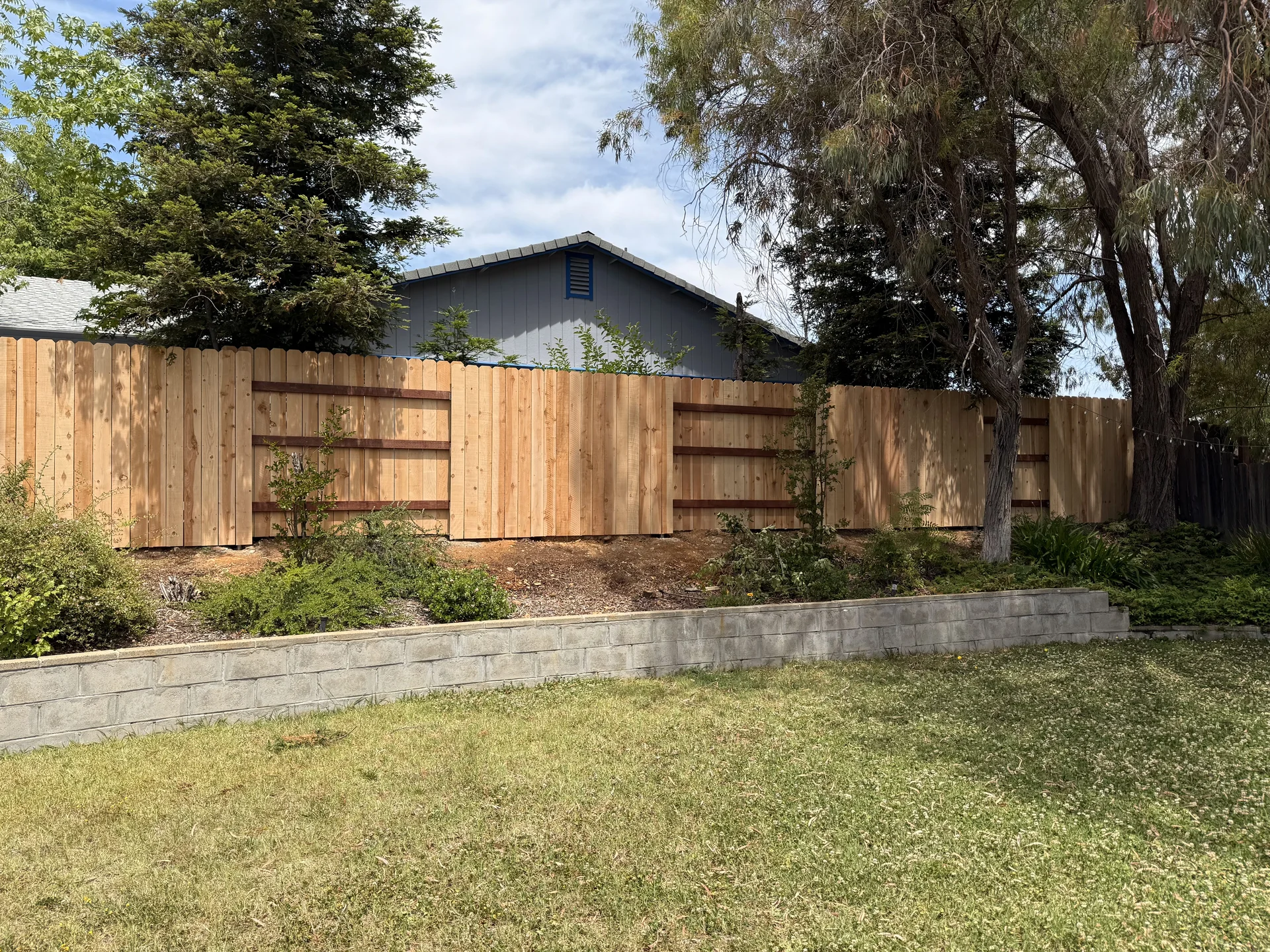 Backyard cedar fence with block retaining wall