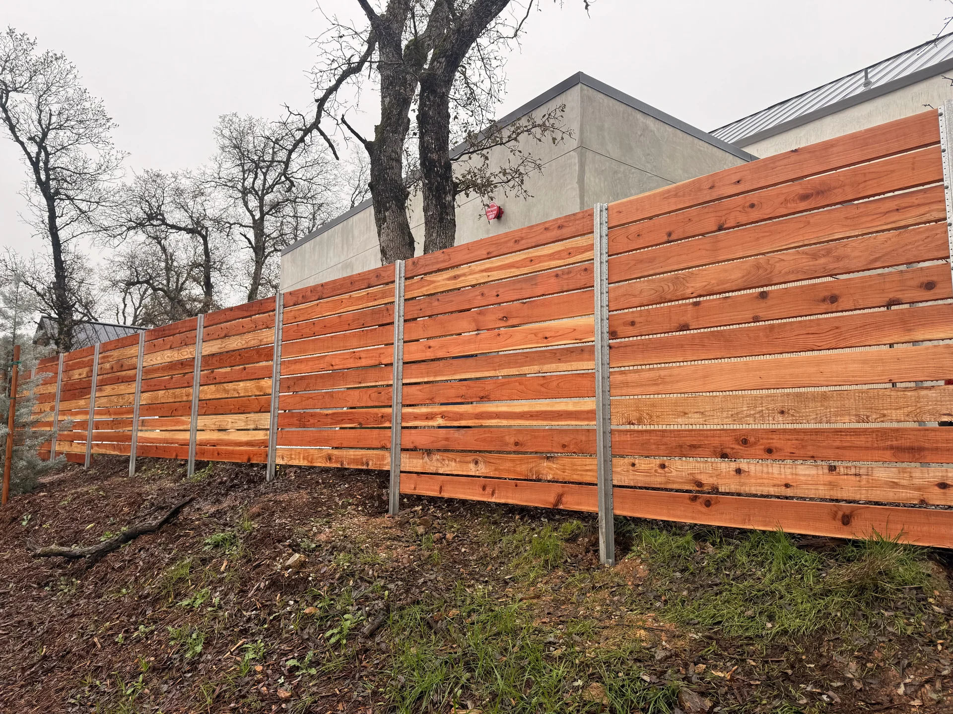 Modern horizontal redwood fence with steel posts
